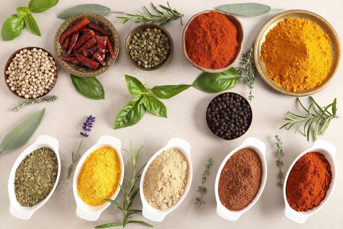 Colorful, aromatic spices and fresh herbs on a light background. Top view.